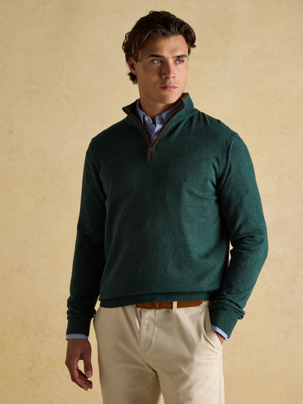 Man wearing a green sweater with a beige background