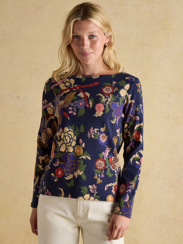 Woman wearing a floral patterned sweater against a beige background