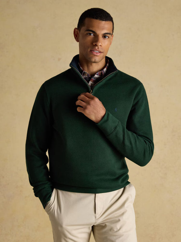 Man wearing a green pullover with a beige background