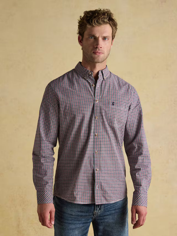 Man wearing a checkered shirt against a beige background