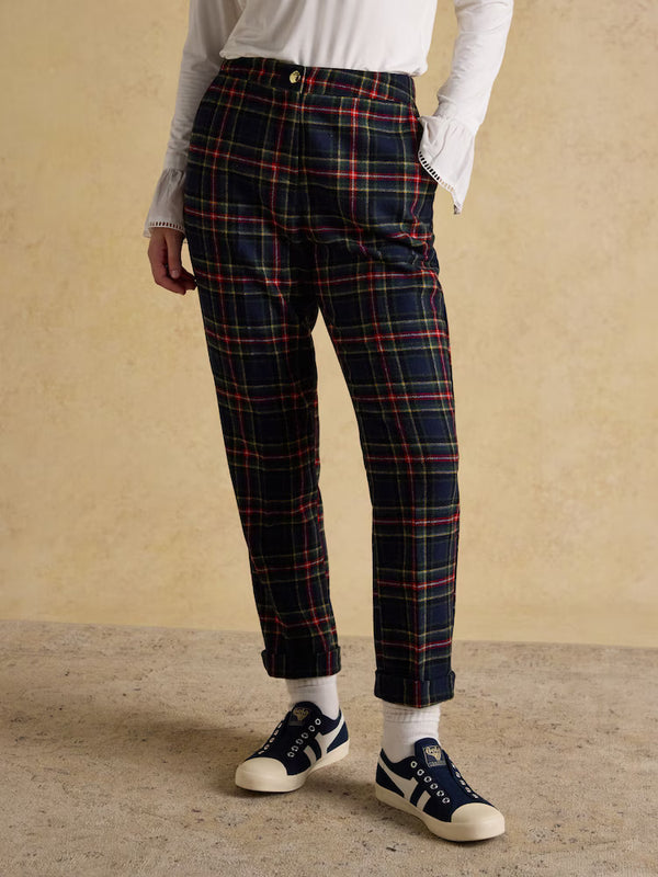 Person wearing plaid pants with a beige background