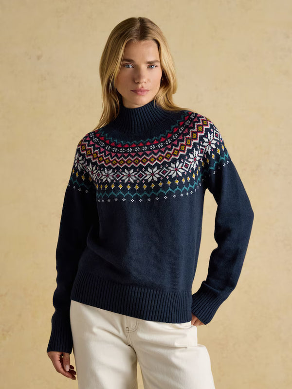 Woman wearing a navy sweater with a colorful pattern on a beige background