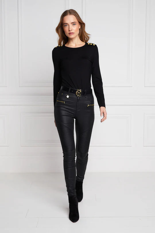 Woman wearing a black outfit with leather pants against a white background