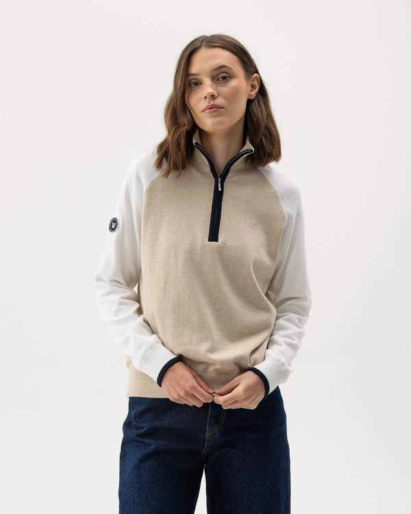 Woman wearing a beige and white pullover with a zipper on a white background