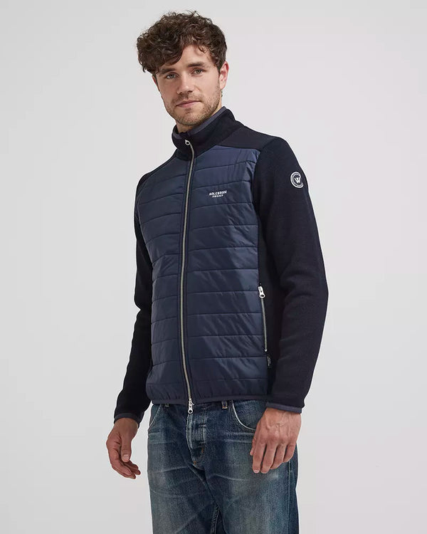 Man wearing a navy quilted jacket with a visible brand logo on a white background