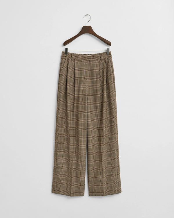 Plaid pants on a hanger against a white background