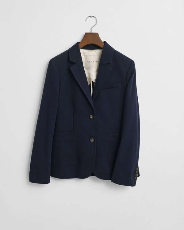 Navy blazer on a hanger against a white background