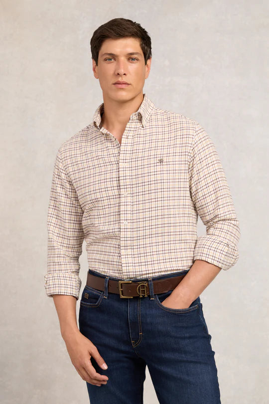 Man wearing a checkered shirt and blue jeans against a plain background