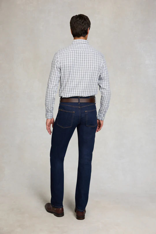 Man wearing a checkered shirt and dark jeans against a plain background