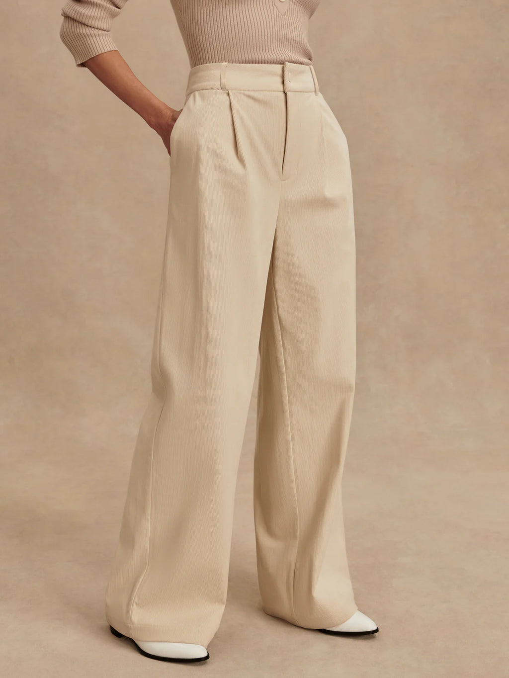 Beige wide-leg pants worn by a person on a beige background