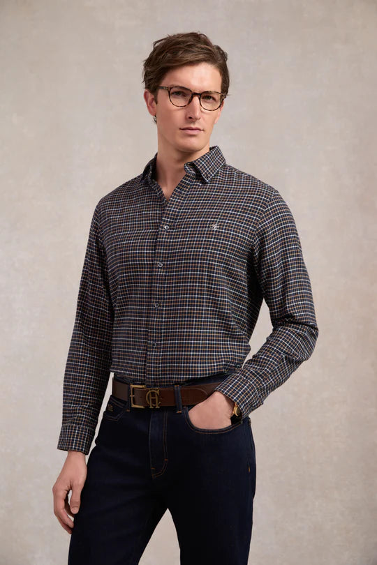 Man wearing a checkered shirt and glasses against a plain background