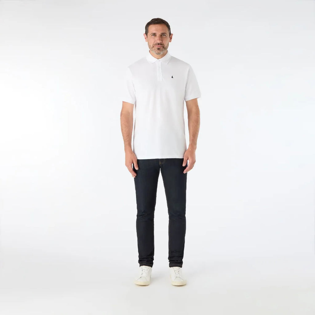 Man wearing a white polo shirt and black jeans on a white background