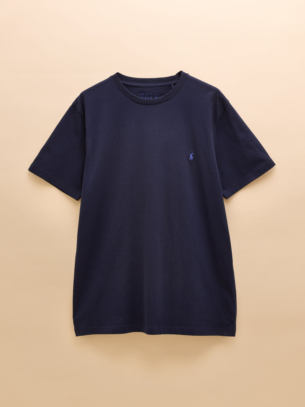 Navy blue t-shirt with a small logo on a beige background