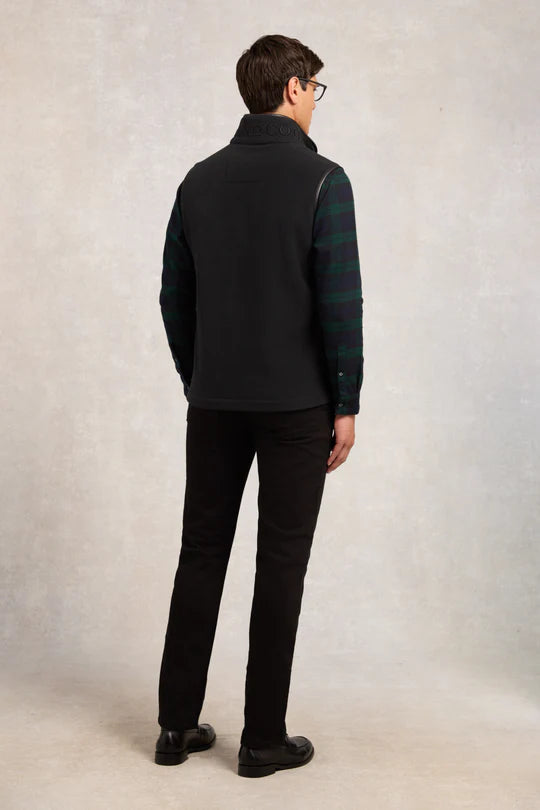 Man wearing a black jacket and pants on a plain background