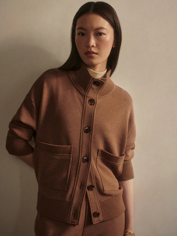 Woman wearing a brown sweater on a beige background