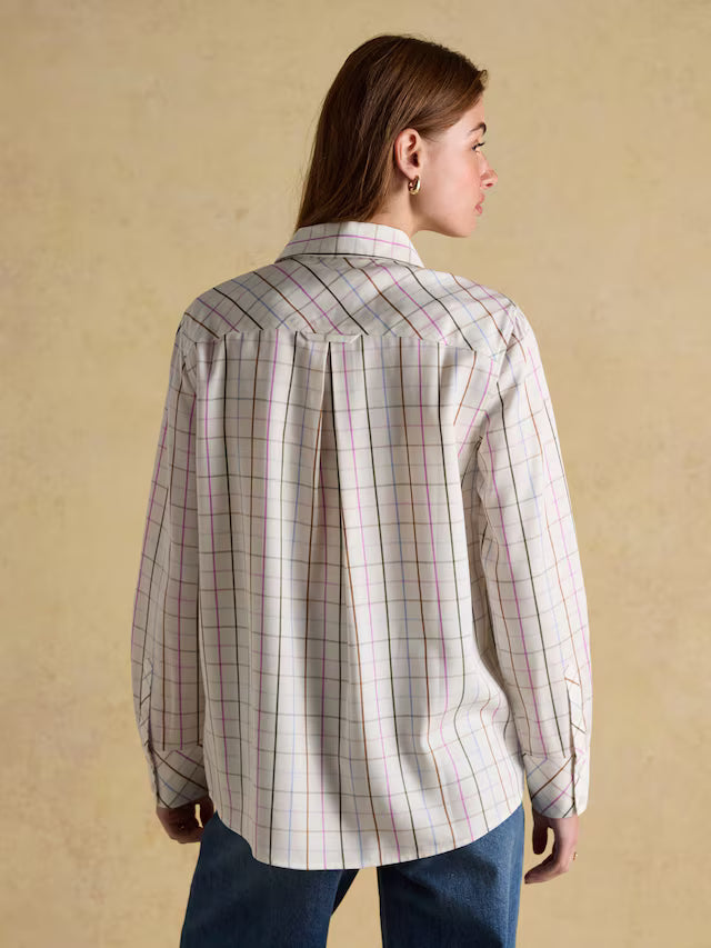 Person wearing a plaid shirt with a beige background