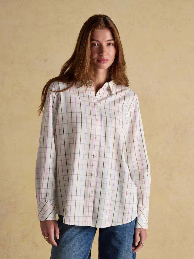 Woman wearing a plaid shirt against a beige background
