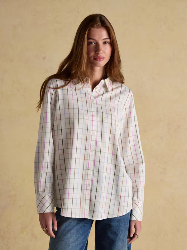 Woman wearing a plaid shirt against a beige background