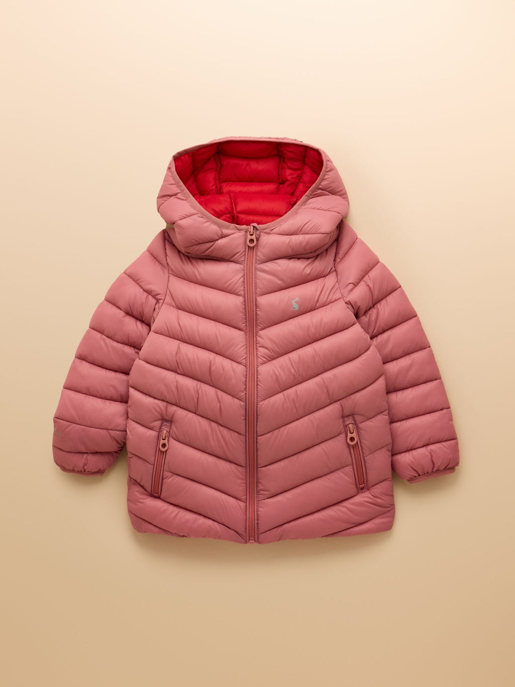 Pink puffer jacket with a red interior on a beige background