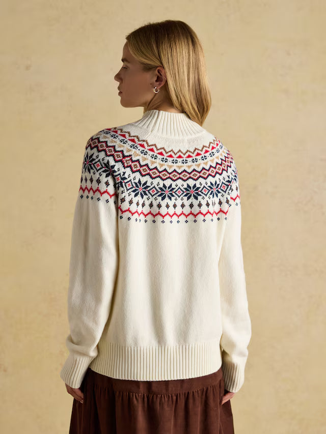 Woman wearing a cream sweater with a patterned yoke against a beige background