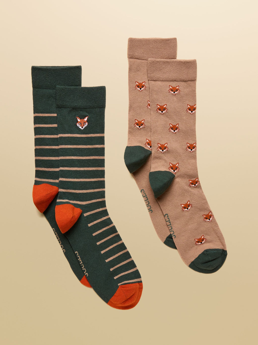 Two pairs of socks with fox patterns on a beige background