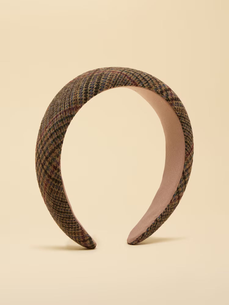 A tweed headband against a yellow background