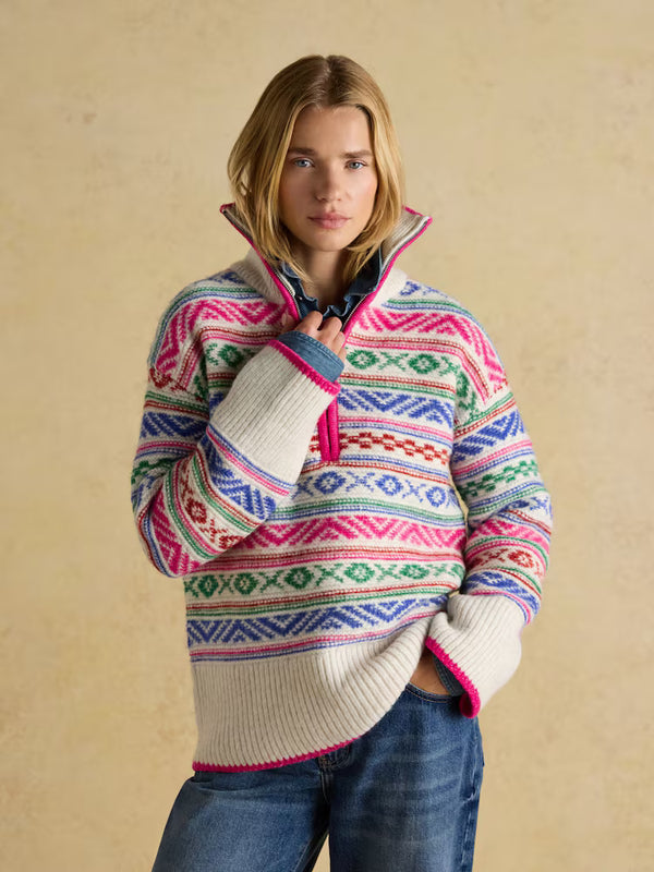 Woman wearing a colorful patterned sweater against a beige background