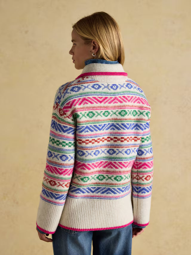 Person wearing a colorful patterned sweater on a beige background