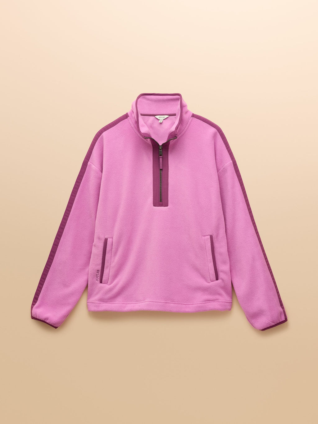 Pink pullover with a quarter zip on a beige background