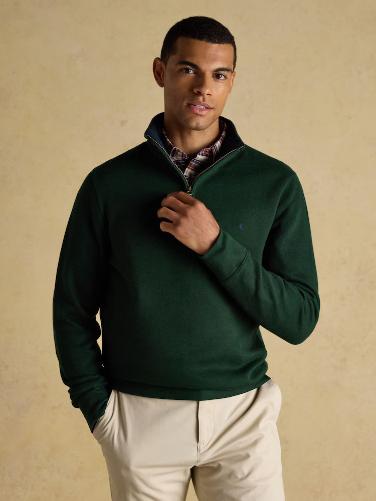 Man wearing a green pullover with a beige background