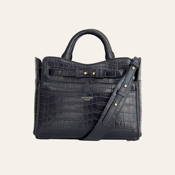 Black crocodile-patterned handbag with a shoulder strap on a light gray background