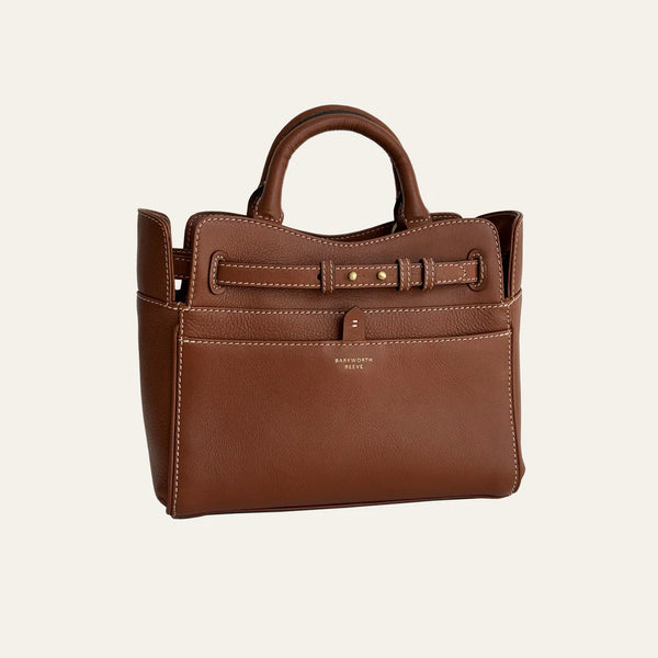 Brown leather handbag with a visible brand name on a light beige background