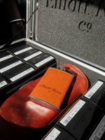 Brown flask placed on an open briefcase.