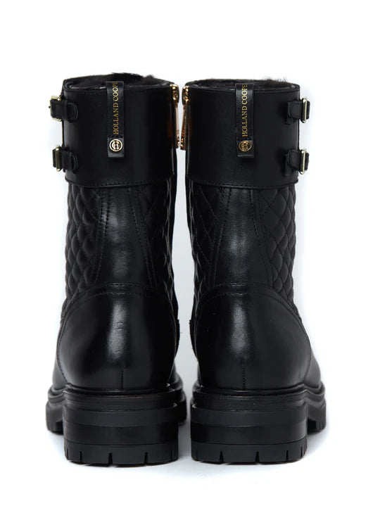 Pair of black quilted boots with buckles on a white background