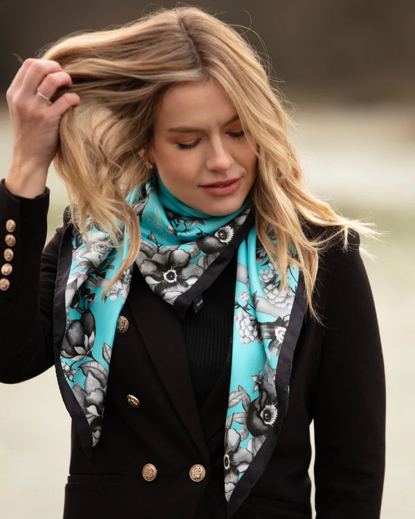 Woman wearing a black coat with a floral patterned scarf