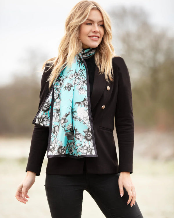 Woman wearing a black coat and floral scarf outdoors