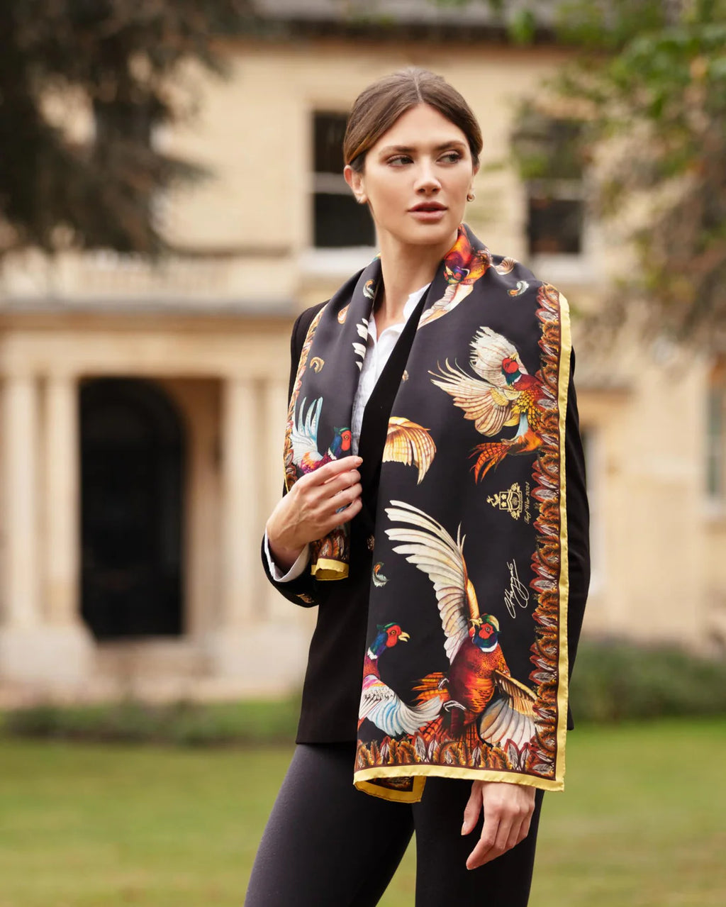 Woman wearing a colorful scarf with bird patterns outdoors.