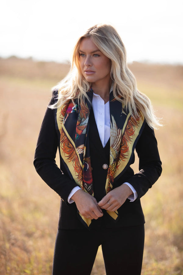 Woman wearing a black outfit with a colorful scarf in an outdoor setting