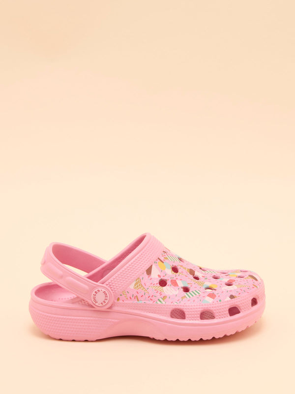 Pink clog shoe with colorful patterns on a beige background