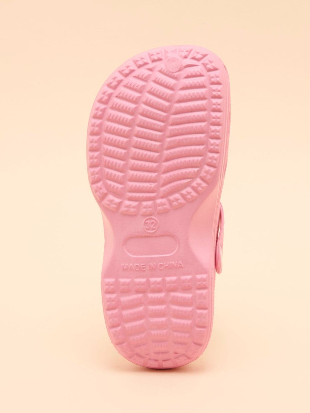 Close-up of a pink shoe sole on a beige background