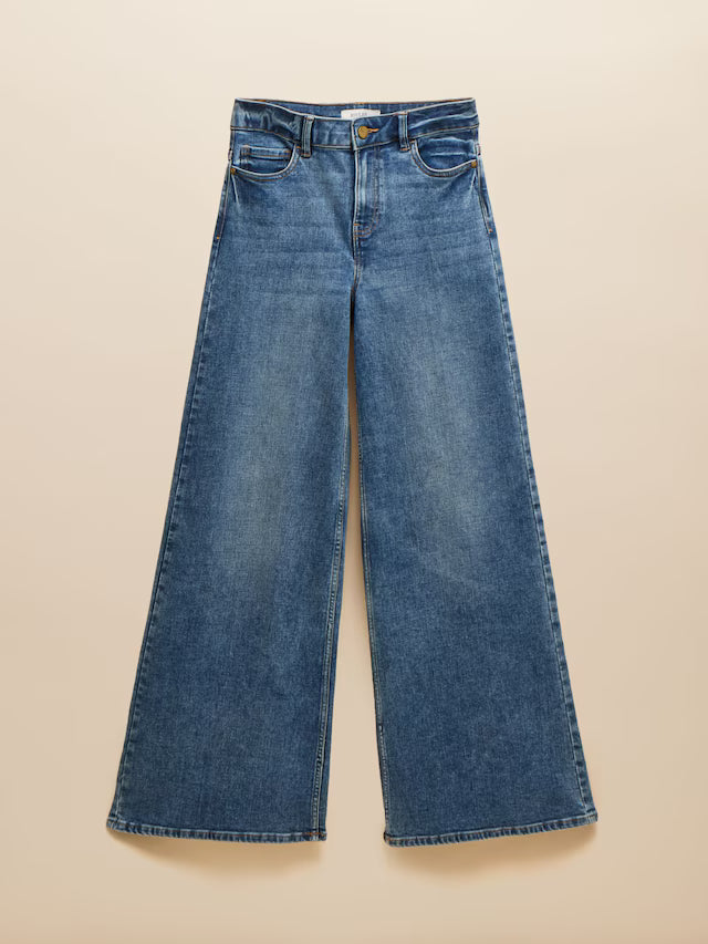 Blue wide-leg jeans on a beige background