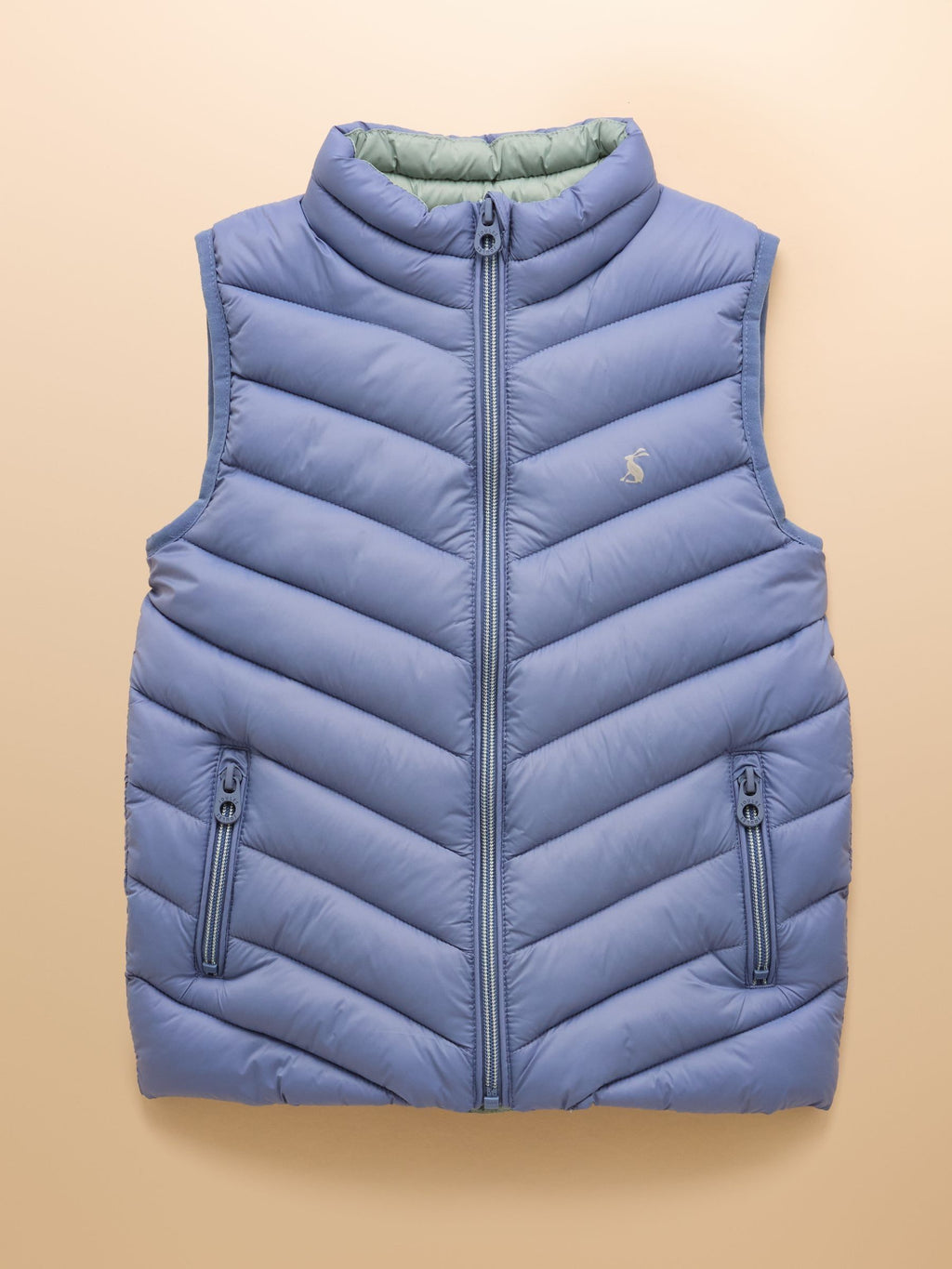 Blue puffer vest on a beige background
