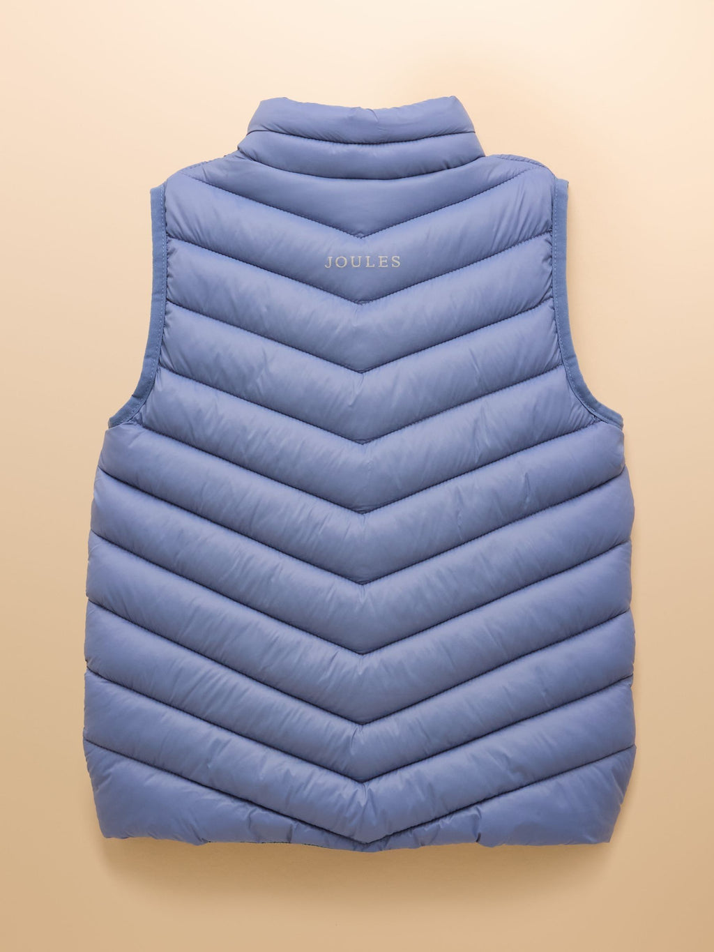 Blue puffer vest on a beige background