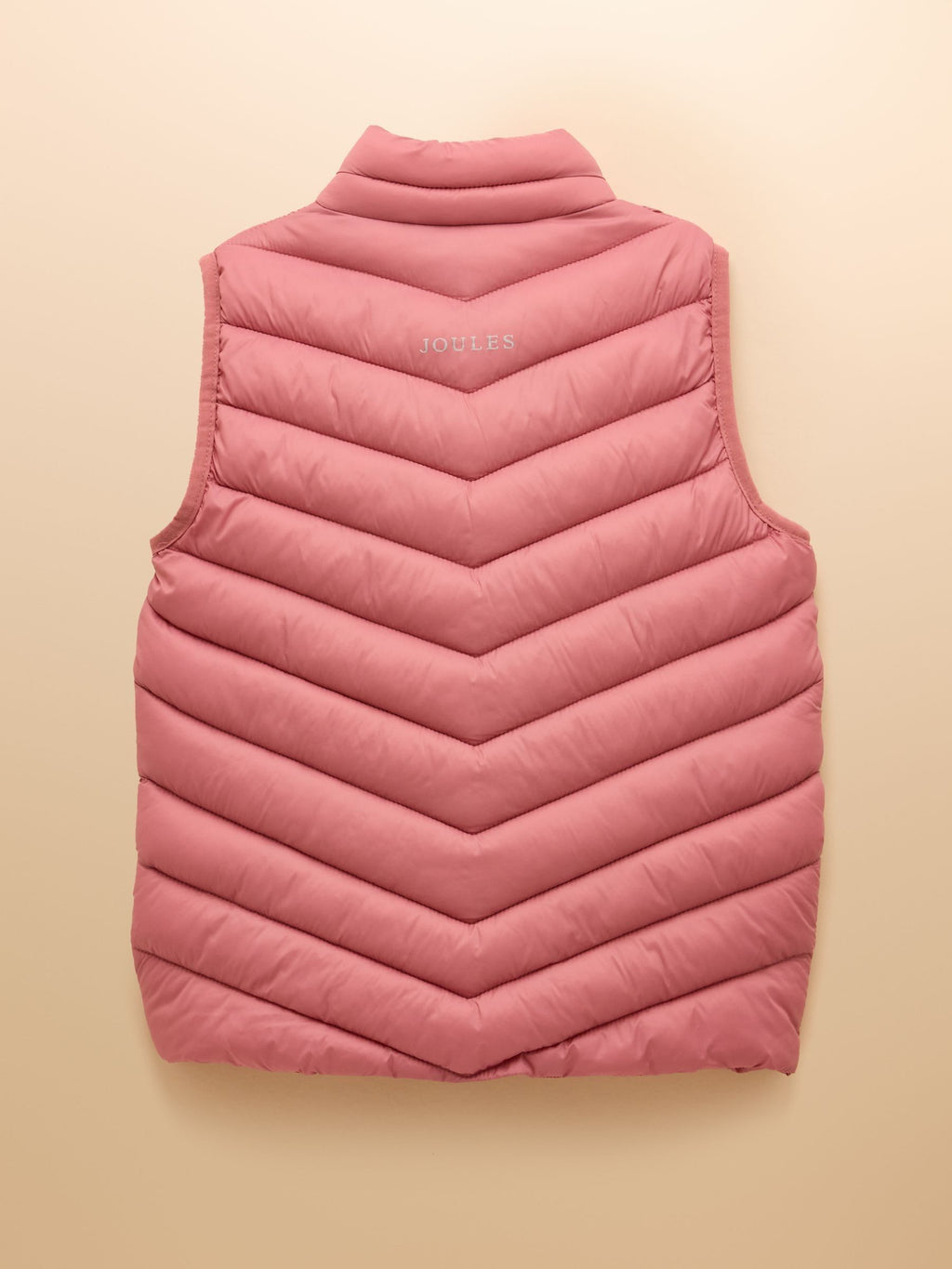 Pink quilted vest on a beige background
