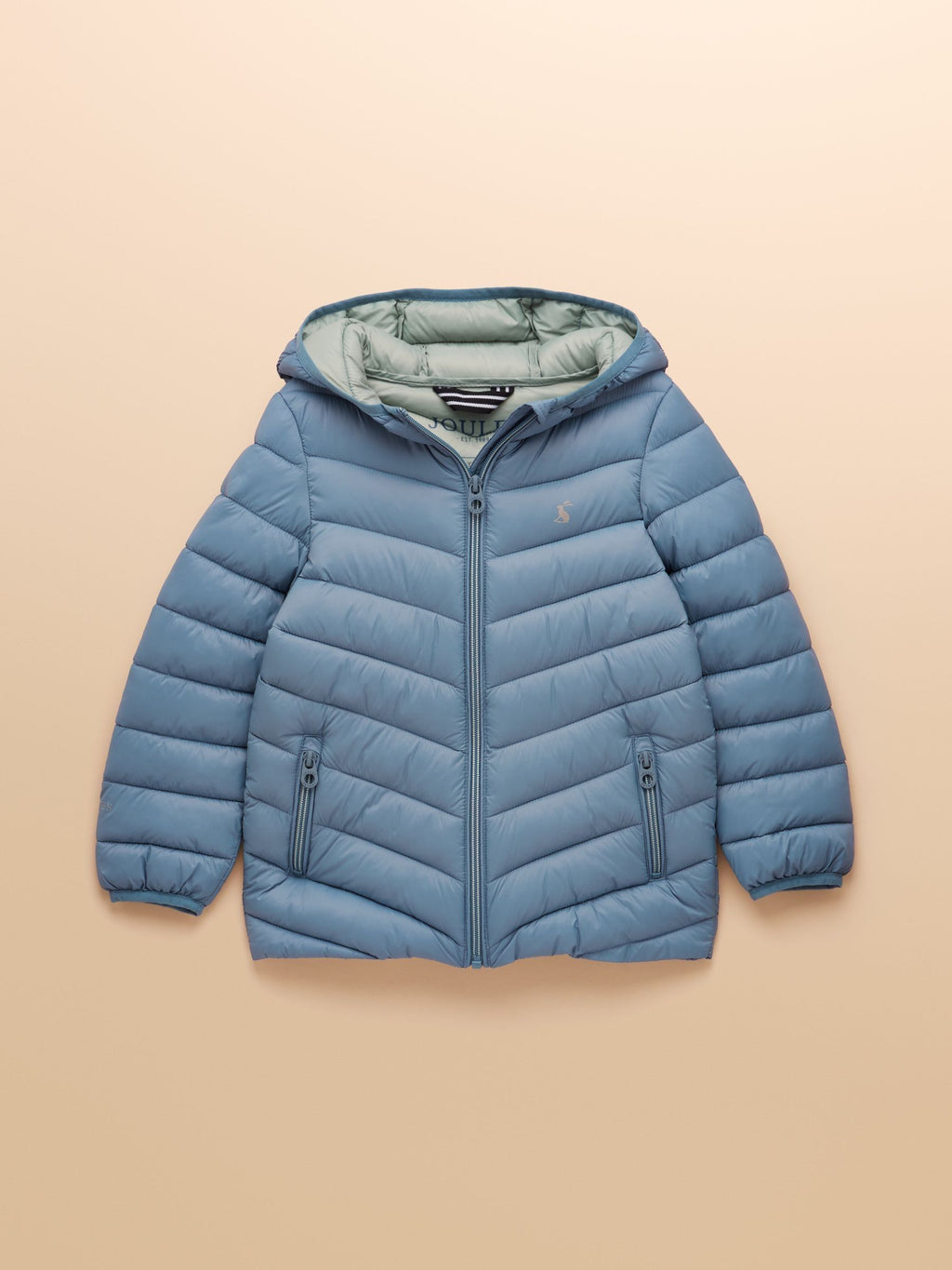 Blue puffer jacket on a beige background