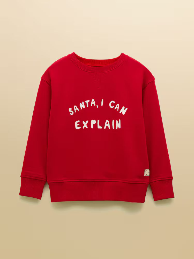 Red sweatshirt with 'Santa, I can explain' text on a beige background