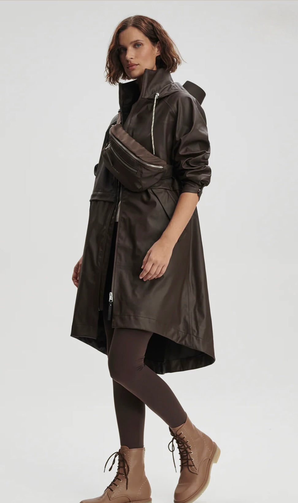 Woman wearing a long dark coat on a white background