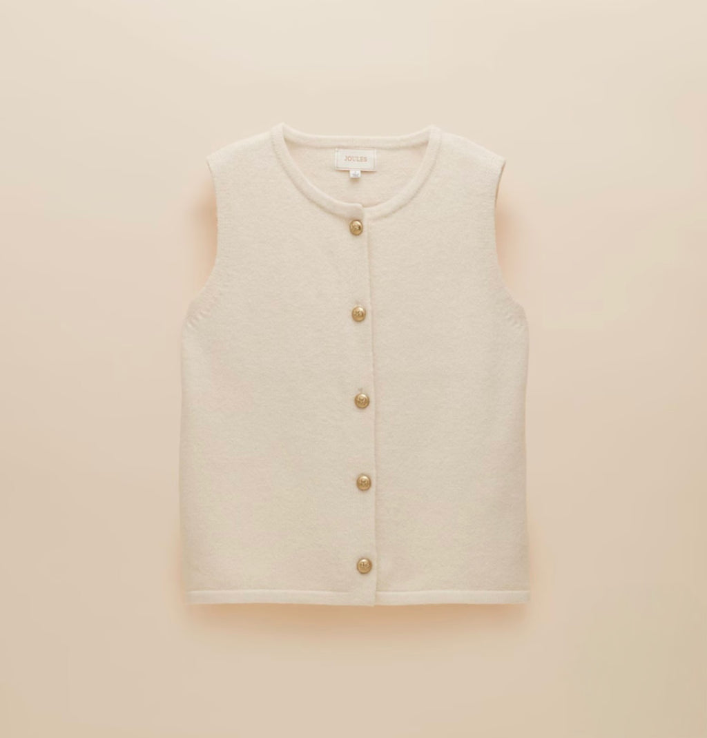 A white sleeveless cardigan on a beige background