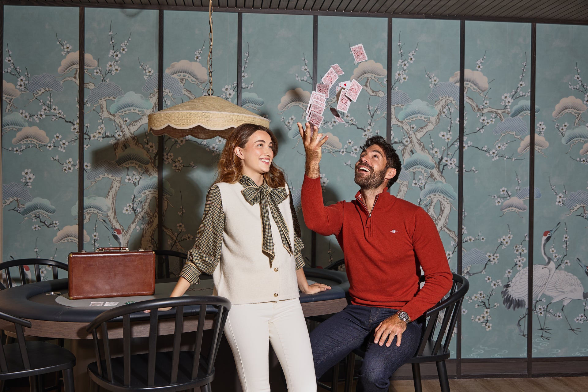 Two people in a room with decorative walls and a table.
