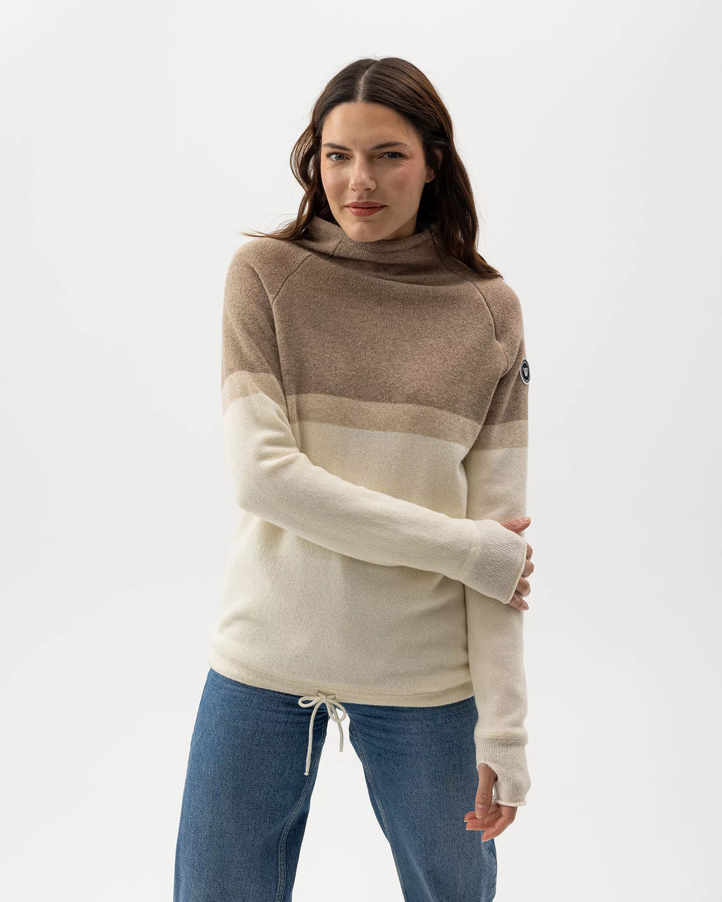Woman wearing a beige and brown color-blocked sweater on a white background